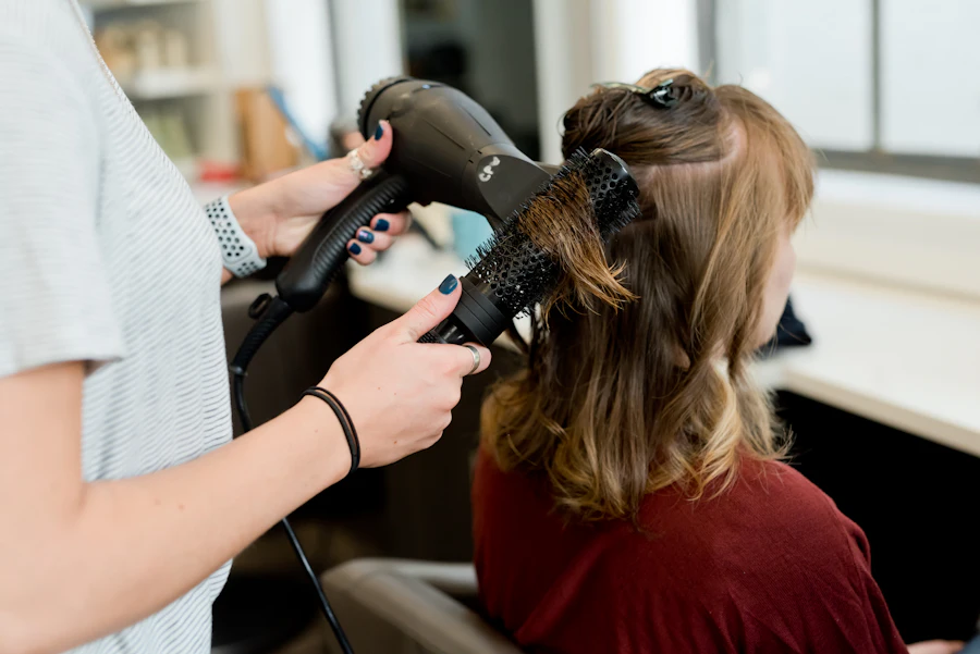 Stylist finishing a client's blowout with a round brush